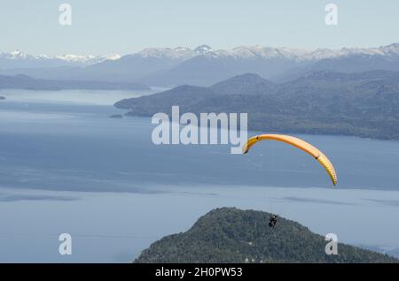 Gente parapendio sul lago Nahuel Huapi e le colline circostanti nella Patagonia settentrionale, Argentina Foto Stock