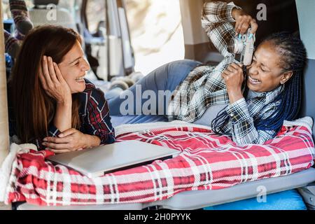Donne multirazziale amici divertirsi scattando foto camping all'interno di camper van- Focus su Senior african woman face Foto Stock