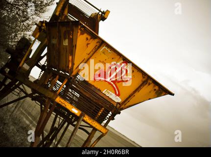 Vecchia macchina per la raccolta delle patate gialle, lasciata arrugginire sul lato di una pista agricola, East Yorkshire, Inghilterra Foto Stock