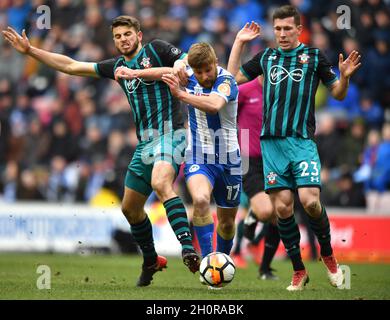 Michael Jacobs di Wigan Athletic evita una sfida da Wesley Hoedt di Southampton (a sinistra) e Pierre-Emile Hojbjerg di Southampton (a destra) Foto Stock