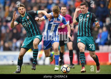 Michael Jacobs di Wigan Athletic evita una sfida da Wesley Hoedt di Southampton (a sinistra) e Pierre-Emile Hojbjerg di Southampton (a destra) Foto Stock