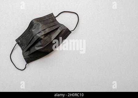Maschera medica protettiva nera. Forte maschera nera per l'ufficio business abbigliamento codice. Vista dall'alto Foto Stock