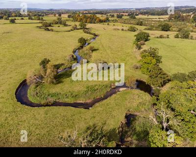 Una vista aerea del piccolo fiume Arrow che attraversa i terreni agricoli nel Warwickshire, Inghilterra. Foto Stock