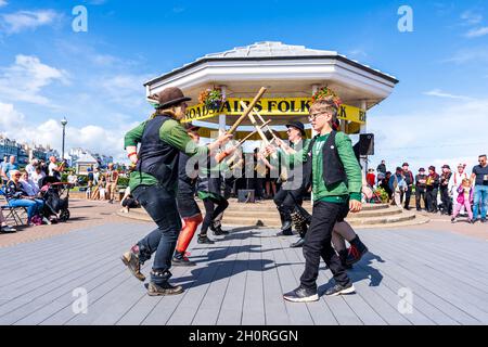 Scopa mattoni e Bowlers Manic Morris uomini ballare di fronte al Bandstand sul lungomare durante l'annuale Broadstairs Folk Week festival. Foto Stock