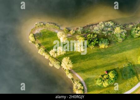 Fuco, zona balneare sulla piccola penisola al lago Rottachsee con capanna, le nuvole si riflettono sulla superficie del lago, Allgaeu, Baviera, tedesco Foto Stock