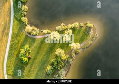 Fuco, zona balneare sulla piccola penisola al lago Rottachsee con capanna, le nuvole si riflettono sulla superficie del lago, Allgaeu, Baviera, tedesco Foto Stock