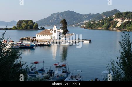 Barche ormeggiate al di fuori della Chiesa di Panagia Vlacherna al mattino, Pontikonisi, Corfù, Grecia Foto Stock