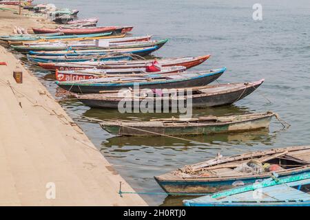 VARANASI, INDIA - 25 OTTOBRE 2016: Piccole barche vicino Ghats scalini che conducono alle rive del fiume Ganges in Varanasi, India Foto Stock