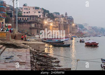 VARANASI, INDIA - 25 OTTOBRE 2016: Piccole barche vicino Ghats scalini che conducono alle rive del fiume Ganges in Varanasi, India Foto Stock