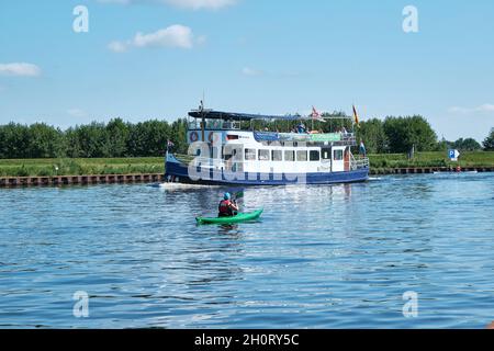 Amersfoort, Hoogland, Paesi Bassi 13 giugno 2021, Barca a vela, traghetto eemland sul fiume EEM con canoista e un cielo blu e dike in Foto Stock