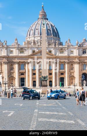 Le auto della polizia e dei carabinieri di fronte alla Basilica di San Pietro. Piazza San Pietro del Vaticano affollata di turisti. Città del Vaticano, Italia Foto Stock