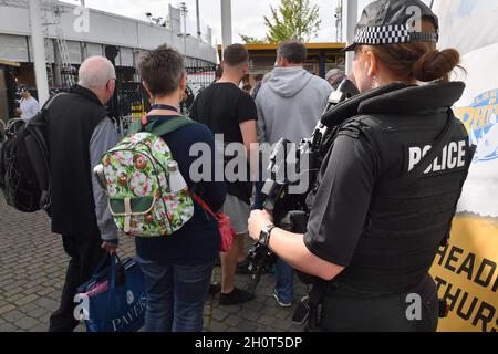 La polizia armata guarda avanti mentre i tifosi si accingono davanti al primo giorno del secondo Investec Test Match all'Headingley Cricket Ground di Leeds, Yorkshire Foto Stock