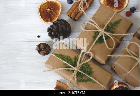 Composizione di Natale. Regali di Natale, coni di pino, rami di abete su sfondo bianco in legno. Foto Stock