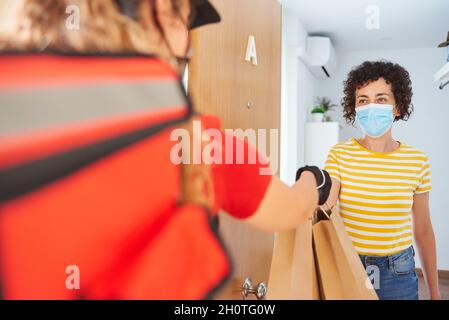 Una donna consegna consegna consegna un ordine di cibo a un cliente Foto Stock