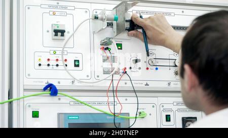 L'operatore controlla il pannello di controllo nella fabbrica moderna. Scena. Il controller di lavoro registra i dati di misurazione dal pannello di controllo aziendale automatizzato. Foto Stock