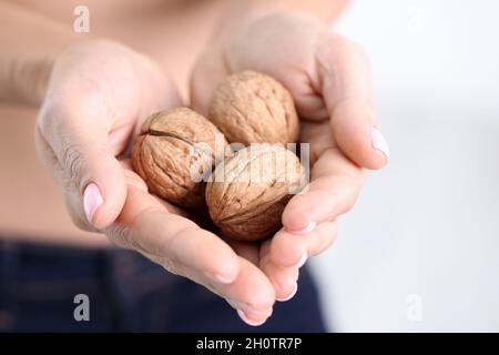 Tre noci mature nelle mani femminili primo piano Foto Stock