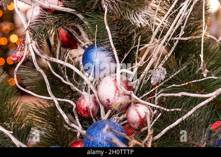 Strade completamente decorate per Natale con palline rosse e dorate. Albero di Natale in città. Casa illuminata con molte luci. Foto Stock