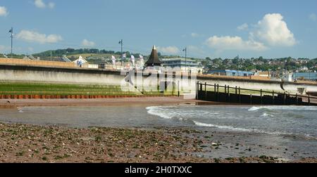 Calce verde sui gradini e mucchi di lamiera d'acciaio lungo la parete marina di Teignmouth a bassa marea. Foto Stock