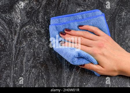 Pulizia del piano di lavoro. Cura dei countertops nella cucina o nella stanza da bagno. Pulizia di superfici in pietra, marmo o pietra artificiale. Salviette per le mani da donna Foto Stock