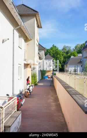 POZNAN, POLONIA - 21 maggio 2014: Un colpo verticale di un piccolo sentiero con una barriera e palazzi di appartamenti in Polonia Foto Stock