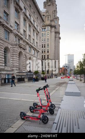 Noleggia scooter elettrici voi parcheggiati vicino all'edificio Liver di Liverpool Foto Stock