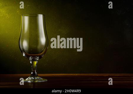Bicchiere di birra vuoto su un tavolo di legno. Sfondo scuro. Concetto di bevanda. Foto Stock