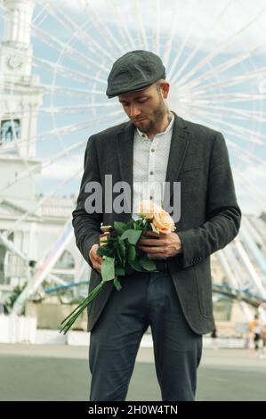 Uomo ucraino in un vestito con un bouquet di rose Foto Stock