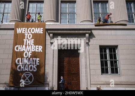 Washington, Stati Uniti. 14 Ott 2021. I manifestanti con il gruppo attivista per il cambiamento climatico Extinction Rebellion hanno scalato la Camera di Commercio degli Stati Uniti d'America e hanno tinto i segni durante una protesta a Washington, DC giovedì 14 ottobre 2021. Foto di Sarah Silbiger/UPI Credit: UPI/Alamy Live News Foto Stock