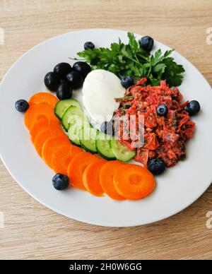 Pezzo di mozzarella, olive nere, verdure variopinte e mirtilli Foto Stock