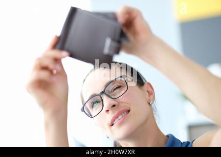 Ritratto di giovane donna con occhiali guarda in borsa vuoto primo piano Foto Stock