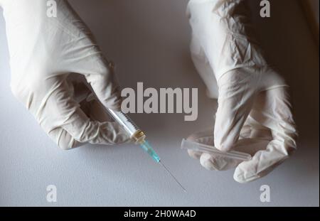 Medico che prepara dosi di vaccino contro covid19 Foto Stock