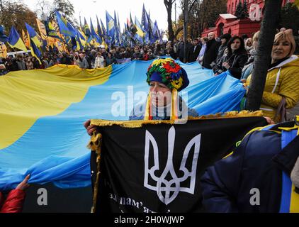 Kiev, Ucraina. 14 Ott 2021. I membri dei movimenti nazionalisti partecipano alla marcia della Nazione per la Giornata del difensore dell'Ucraina e all'anniversario dell'Esercito Insurgente ucraino (UPA). L'esercito insurgente ucraino combatté per l'indipendenza dell'Ucraina contro l'esercito rosso sovietico e i nazisti durante il WW II. Dal 2021, il 14 ottobre, anche gli ucraini hanno segnato questa giornata come la Giornata dei difensori dell'Ucraina. (Foto di Sergei Chuzavkov/SOPA Images/Sipa USA) Credit: Sipa USA/Alamy Live News Foto Stock