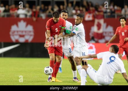 Toronto, Canada, 13 ottobre 2021: Steven Vitória, n.5, del Team Canada è affrontato da due giocatori del Team Panama, Aníbal Godoy, n.20, ed Eric Davis, n.15, durante la gara di qualificazione CONCACACAF FIFA World Cup 2022 al BMO Field di Toronto, Canada. Il Canada ha vinto la partita 4-1. Credit: Phamai Techaphan/Alamy Live News Foto Stock