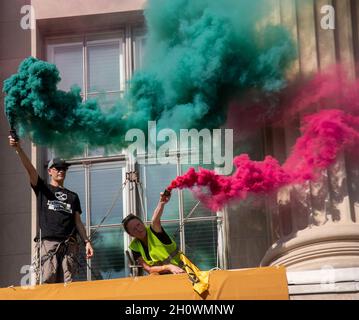 Washington, Stati Uniti. 14 Ott 2021. Gli attivisti ambientali del gruppo Extinction Rebellion fanno ondare bombe fumogene fuori da una seconda finestra della Camera di Commercio degli Stati Uniti come una protesta della posizione dell'organizzazione sul cambiamento climatico a Washington, DC il 14 ottobre 2021. Gli attivisti hanno raggiunto la seconda parte della scala per svelare due grandi striscioni, e sono stati interrogati e rilasciati dalla polizia alla loro discesa. (Foto di Matthew Rodier/Sipa USA) Credit: Sipa USA/Alamy Live News Foto Stock