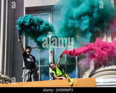 Washington, Stati Uniti. 14 Ott 2021. Gli attivisti ambientali del gruppo Extinction Rebellion fanno ondare bombe fumogene fuori da una seconda finestra della Camera di Commercio degli Stati Uniti come una protesta della posizione dell'organizzazione sul cambiamento climatico a Washington, DC il 14 ottobre 2021. Gli attivisti hanno raggiunto la seconda parte della scala per svelare due grandi striscioni, e sono stati interrogati e rilasciati dalla polizia alla loro discesa. (Foto di Matthew Rodier/Sipa USA) Credit: Sipa USA/Alamy Live News Foto Stock