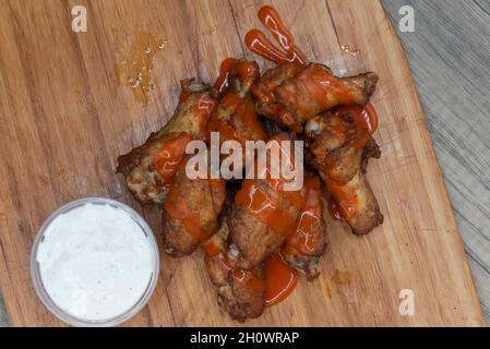 La vista dall'alto del piatto laterale delle ali di pollo alla bufala gocciolate è l'antipasto perfetto per un pasto abbondante da mangiare. Foto Stock