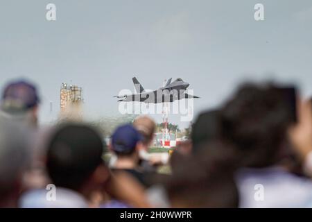 Gli spettatori guardano come il Major dell'aeronautica degli Stati Uniti Josh Gunderson, pilota e comandante della squadra di dimostrazione F-22, decolli durante il Wings Over Houston Airshow, 10 ottobre 2021, all'aeroporto di Ellington, Houston, Texas. Il team vola in airshow in tutto il mondo, eseguendo manovre che dimostrano le capacità degli aerei da caccia di quinta generazione. (STATI UNITI Air Force foto di staff Sgt. Don Hudson) Foto Stock