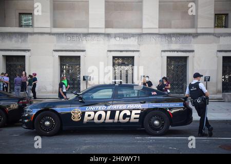 Washington, Stati Uniti. 14 Ott 2021. L'ufficiale di polizia si alza in guardia da un'auto durante la dimostrazione. Attivisti ambientali arrestati dopo aver occupato il Bureau of Indian Affairs presso il Department of Interior. Credit: SOPA Images Limited/Alamy Live News Foto Stock