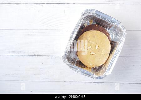 primo piano di biscotti dolci nella scatola da togliere su tavola di legno Foto Stock