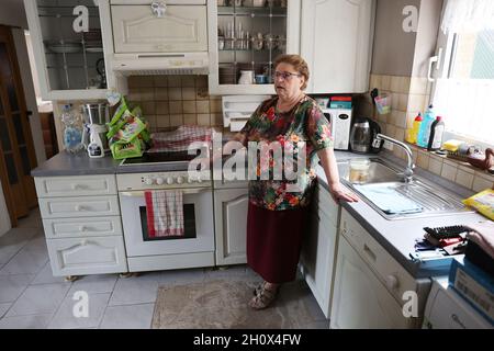 Erftstadt, Germania. 13 ottobre 2021. Susanne Dunkel si trova nella sua nuova cucina nella sua casa nel quartiere di Blessem, appena tre mesi dopo l'apertura della terra a Erftstadt la notte del 15 luglio 2021, e inghiottì diverse case. Ha ottenuto la cucina come un regalo. Ma ancora il suo piccolo appartamento è quasi vuoto. Con l'aiuto d'emergenza poteva pagare solo una nuova porta d'ingresso. (A dpa: ''You take that to the grave' - Un quarto d'anno dopo l'alluvione') Credit: Oliver Berg/dpa/Alamy Live News Foto Stock