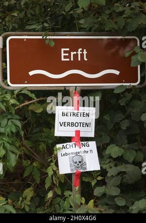 Erftstadt, Germania. 13 ottobre 2021. Un cartello dietro un nastro di barriera su un ponte punta al fiume Erft nel distretto di Blessem, sotto il quale si trovano ulteriori indicazioni che dicono "non entrare" e "attenzione, pericolo per la vita". A Blessem, la terra si aprì nella notte del 15 luglio e inghiottì diverse case. (A dpa: ''You take that to the grave' - Un quarto d'anno dopo l'alluvione') Credit: Oliver Berg/dpa/Alamy Live News Foto Stock