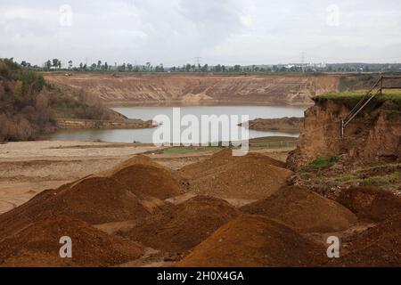 Erftstadt, Germania. 13 ottobre 2021. Tumuli di terra si trovano sul bordo della cava di fronte alla fossa di ghiaia nel distretto di Blessem. Lì, nella notte del 15 luglio, la terra si aprì e inghiottì diverse case. Il foro è un'attrazione, la foto aerea di esso è andato intorno al mondo. (A dpa: ''questo è ciò che si prende alla tomba' - Un quarto d'anno dopo l'alluvione') credito: Oliver Berg/dpa/Alamy Live News Foto Stock