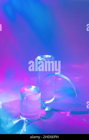 due podi in vetro trasparente su sfondo rosa pastello Foto Stock