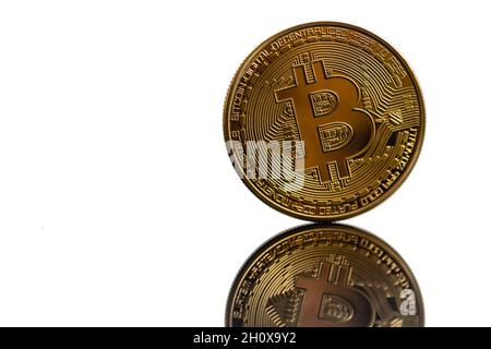 Primo piano bitcoin dorato con riflesso isolato su sfondo bianco. Bitcoin si riflette nello specchio. Foto Stock