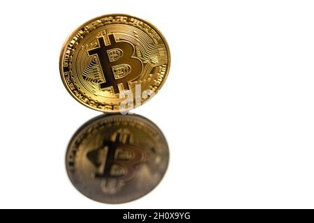 Primo piano bitcoin dorato con riflesso isolato su sfondo bianco. Bitcoin si riflette nello specchio. Foto Stock