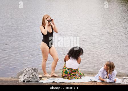 Gruppo di amici che riposano sul lago Foto Stock