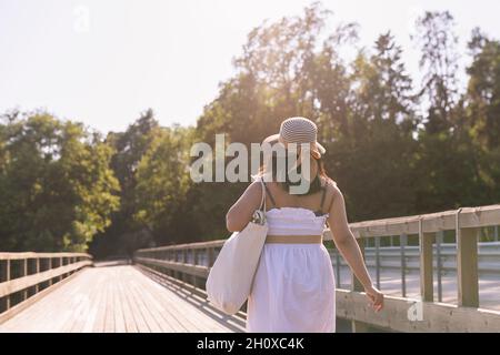 Vista posteriore della donna che cammina al molo Foto Stock