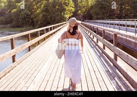 Vista posteriore della donna che cammina al molo Foto Stock