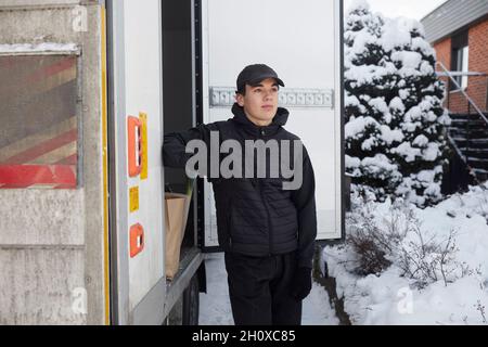 Corriere in piedi vicino al camion Foto Stock