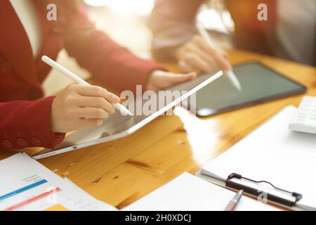 Due donne d'affari che lavorano insieme e utilizzano il tablet digitale per prendere l'elenco e prendere nota dell'importante argomento della riunione Foto Stock